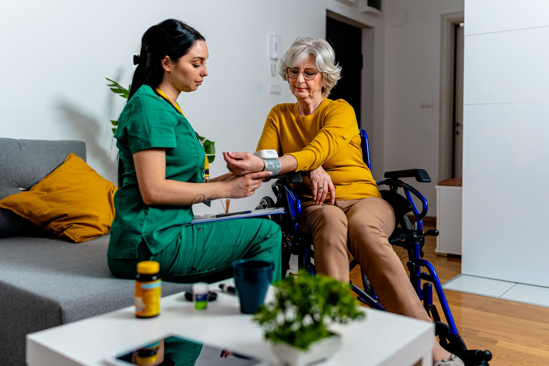 Volunteer Helps Monitor Senior Woman's Health with Blood Pressure Check